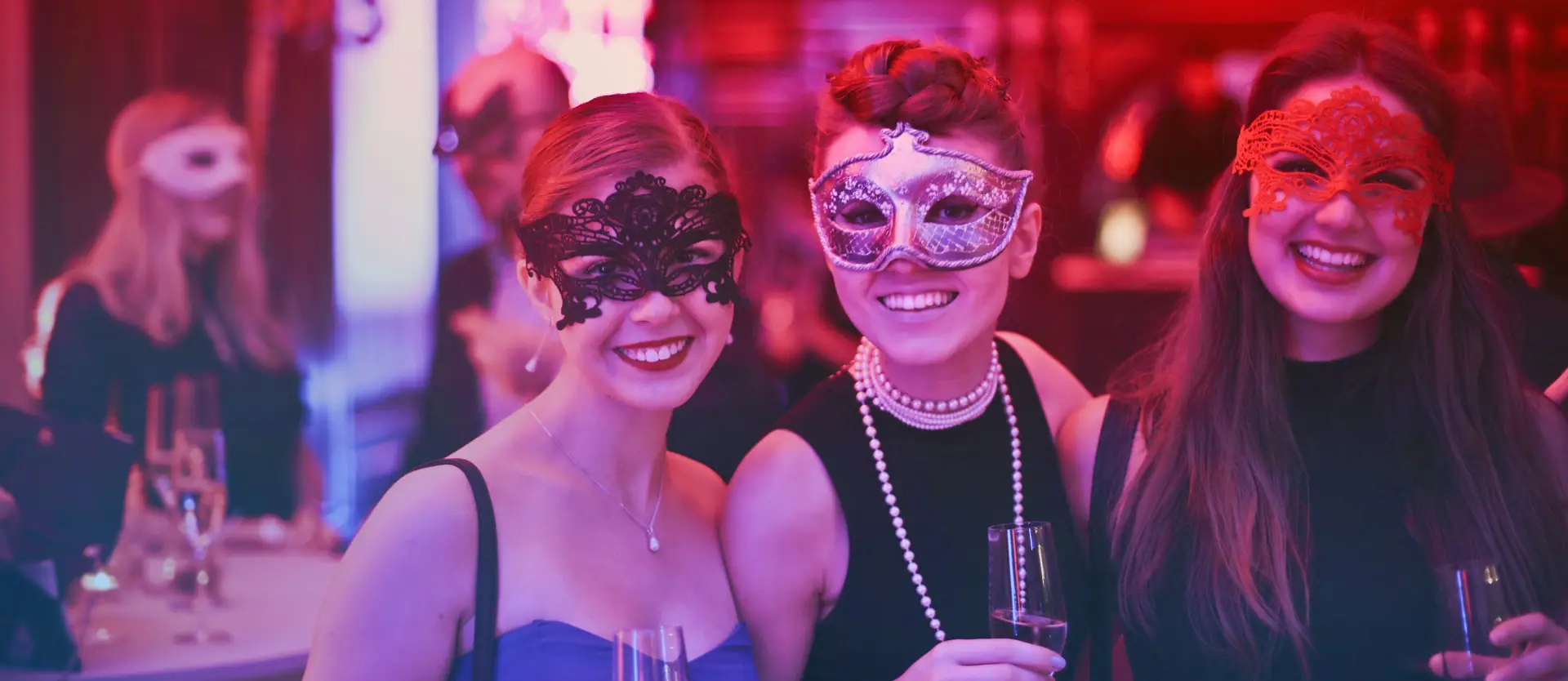 Friends in masquerade masks enjoying a night out at a bar