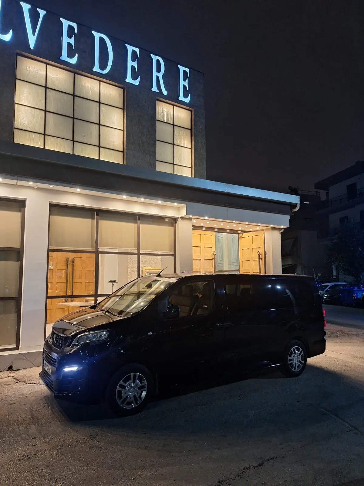 Mini van Peugeot Traveller έξω από φωτισμένο χώρο εκδηλώσεων τη νύχτα